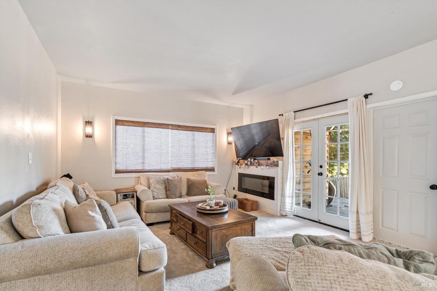 8061 Elphick Road Sebastopol, CA 95472 - Photo 5 of 40 a living room with furniture flat screen tv and a fireplace