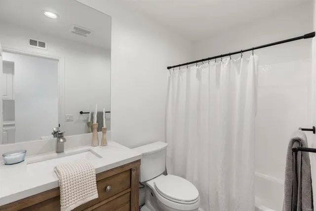 a bathroom with a sink a toilet and shower curtain