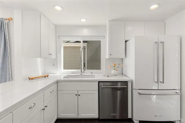 a kitchen with stainless steel appliances white cabinets and a sink