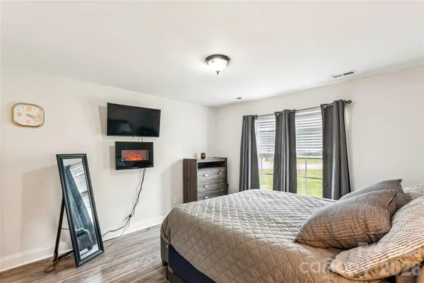 a bedroom with a bed a flat screen tv and a large window