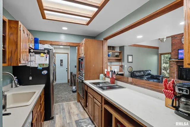 a kitchen with stainless steel appliances kitchen island granite countertop a sink stove and cabinets