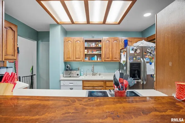 a living room with stainless steel appliances kitchen island granite countertop a rug kitchen view and living room view