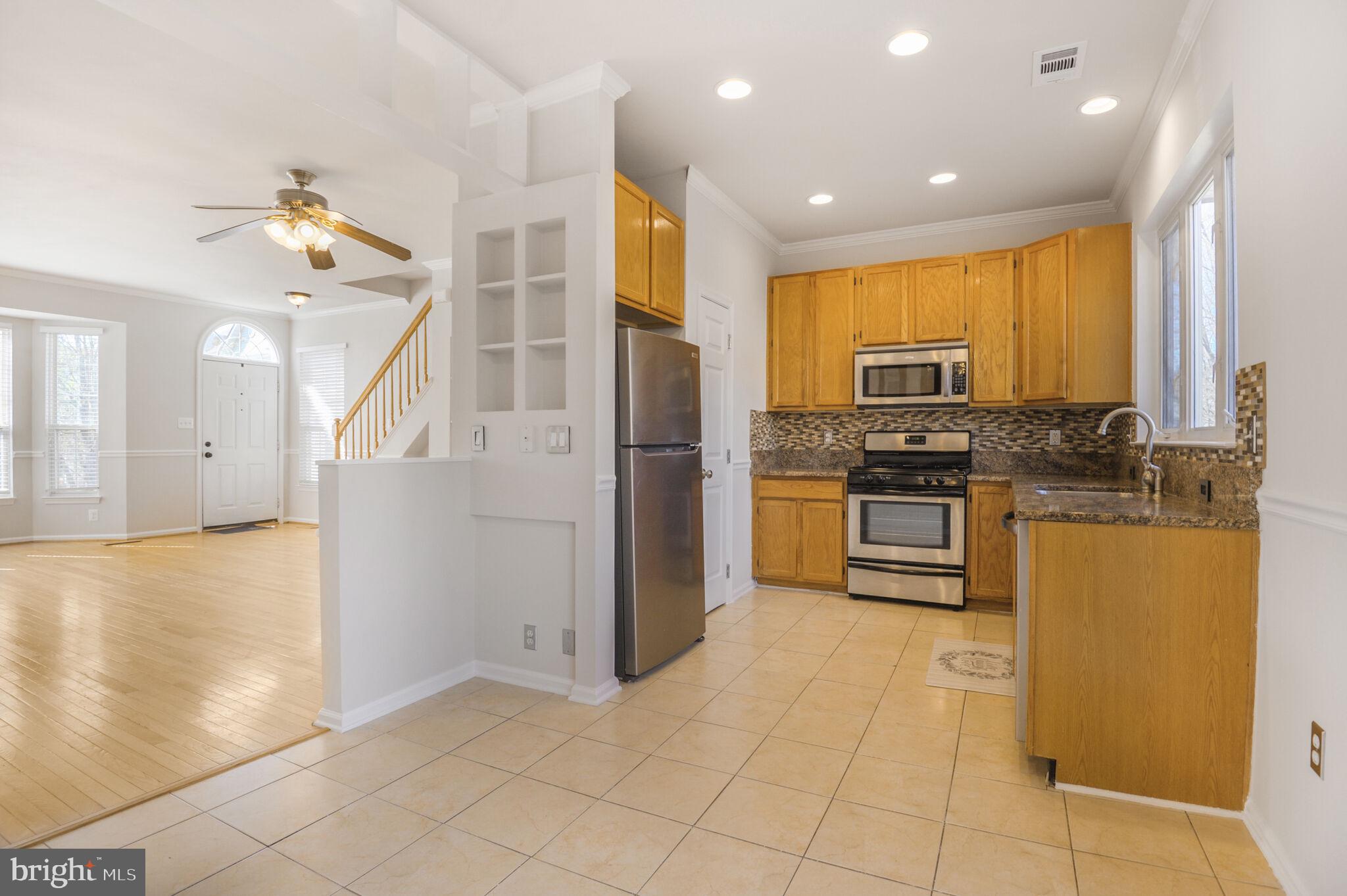 14812 Edman Circle Centreville, VA 20121 - Photo 5 of 24 a kitchen with stainless steel appliances granite countertop a refrigerator a stove and a sink