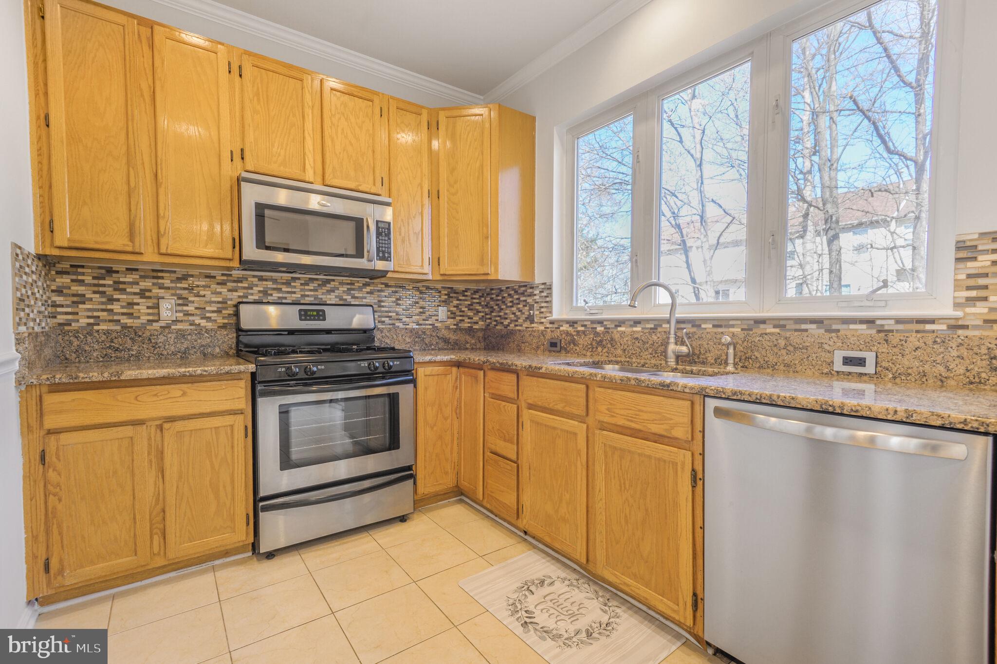 14812 Edman Circle Centreville, VA 20121 - Photo 6 of 24 a kitchen with stainless steel appliances granite countertop a stove a sink and a microwave