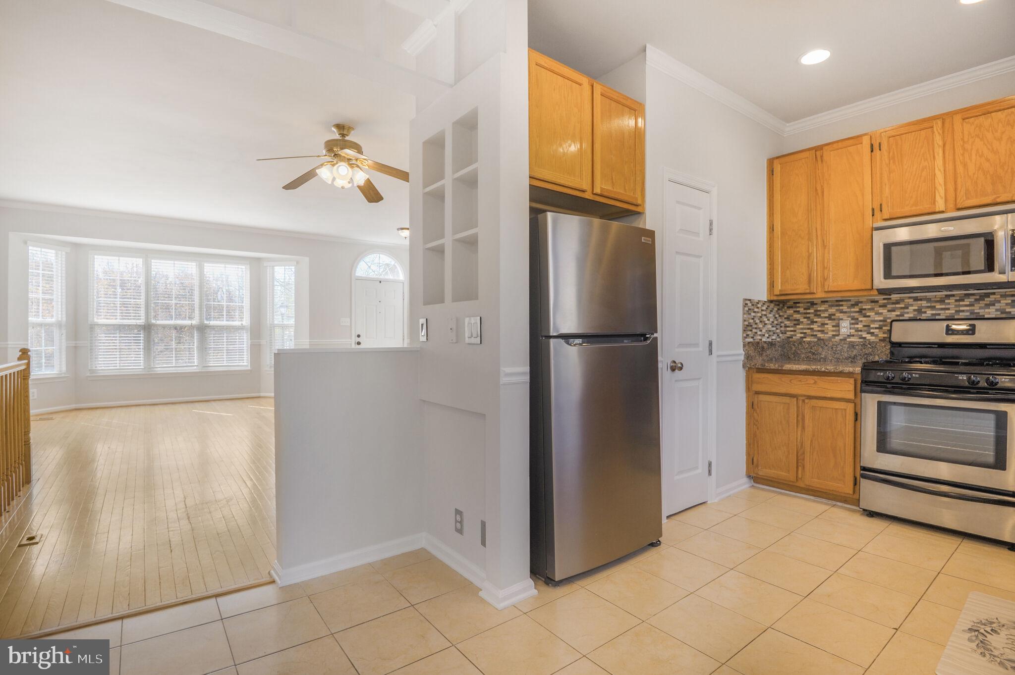 14812 Edman Circle Centreville, VA 20121 - Photo 7 of 24 a kitchen with a refrigerator a stove top oven and cabinets