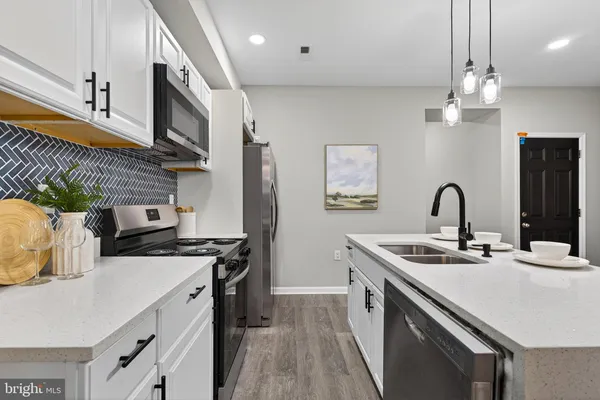 a kitchen with stainless steel appliances a sink a stove and a wooden floors