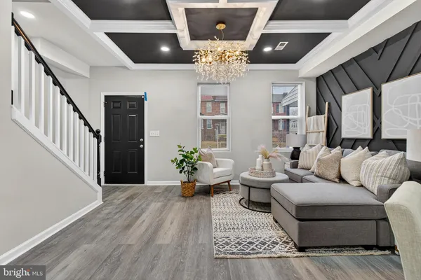 a living room with furniture or chandelier and a wooden floor