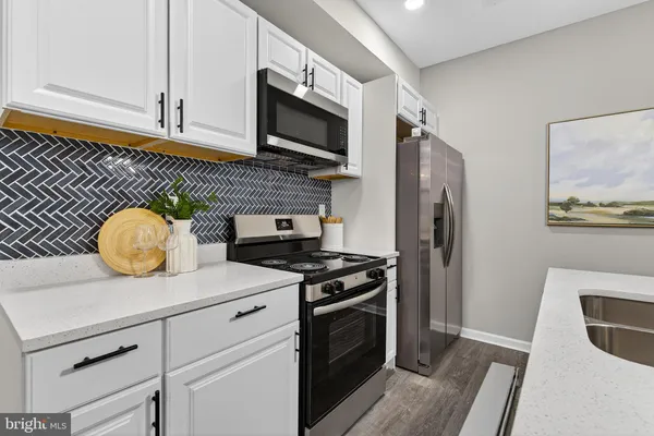 a kitchen with stainless steel appliances a stove microwave and refrigerator