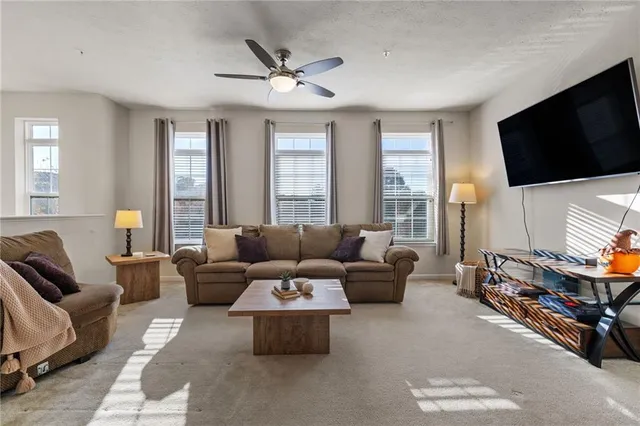a living room with furniture a flat screen tv and a window