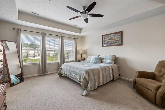 a spacious bedroom with a bed a couch and a window