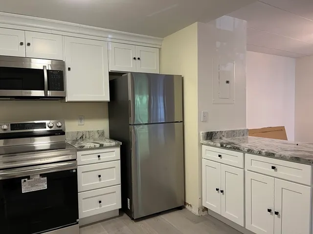a kitchen with granite countertop cabinets and steel stainless steel appliances