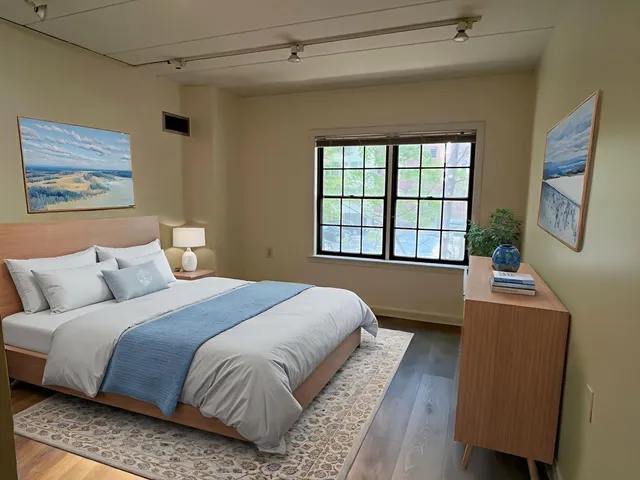 a bedroom with a large bed and a window
