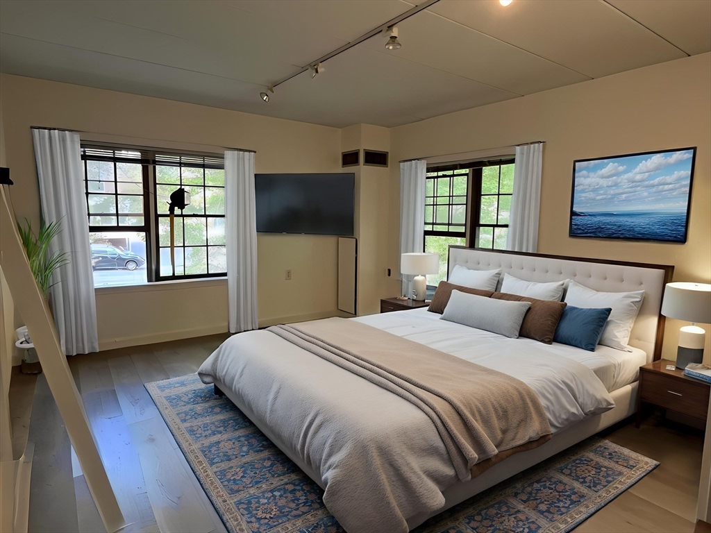 324 Washington Street, Unit 103 Wellesley, MA 02481 - Photo 3 of 13 a bedroom with bed and wooden floor