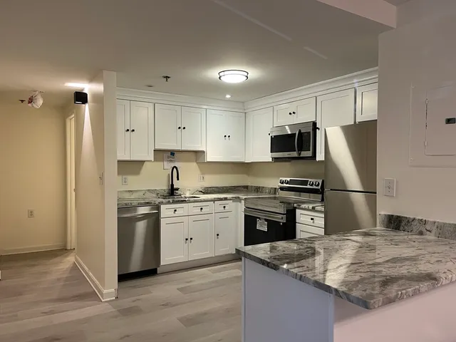 a kitchen with stainless steel appliances granite countertop a stove refrigerator sink and microwave