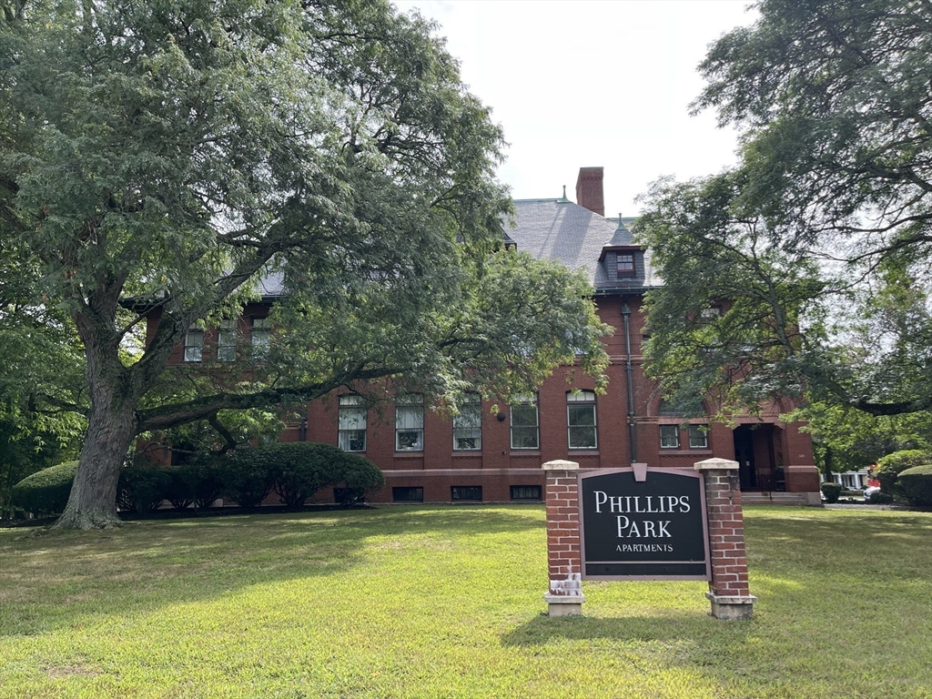 324 Washington Street, Unit 103 Wellesley, MA 02481 - Photo 6 of 13 a sign board with a bench and trees