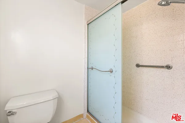 a white toilet sitting next to a shower