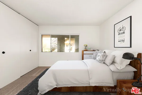 a bedroom with a bed and a painting on the wall