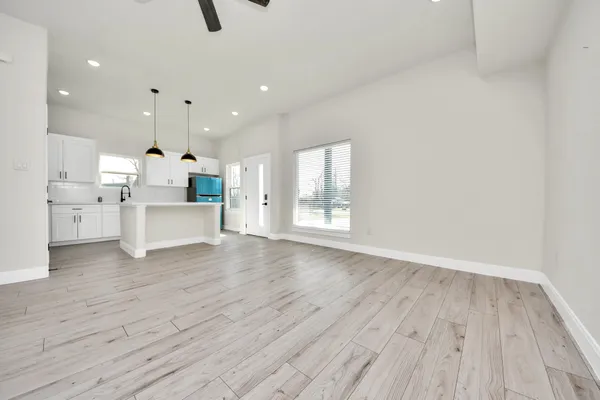 a view of kitchen with white wooden cabinets and stainless steel appliances