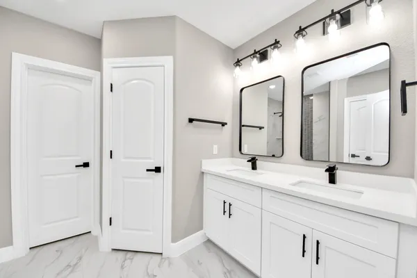 a bathroom with a double vanity sink mirror and