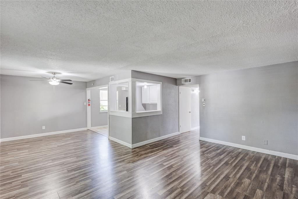 5063 Ridglea Lane, Unit 1002 Fort Worth, TX 76116 - Photo 3 of 11 a view of an empty room with wooden floor and a window