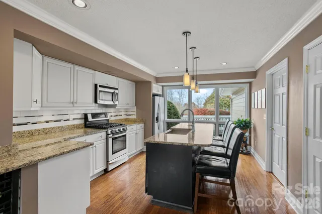 a kitchen with stainless steel appliances granite countertop a sink a stove and a refrigerator