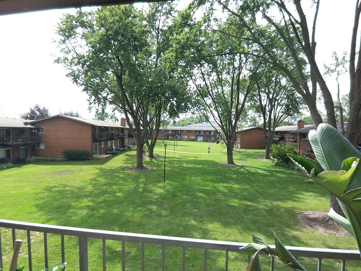 1500 Busse Road, Unit 2D Mount Prospect, IL 60056 - Photo 14 of 18 a view of a backyard with a garden and trees