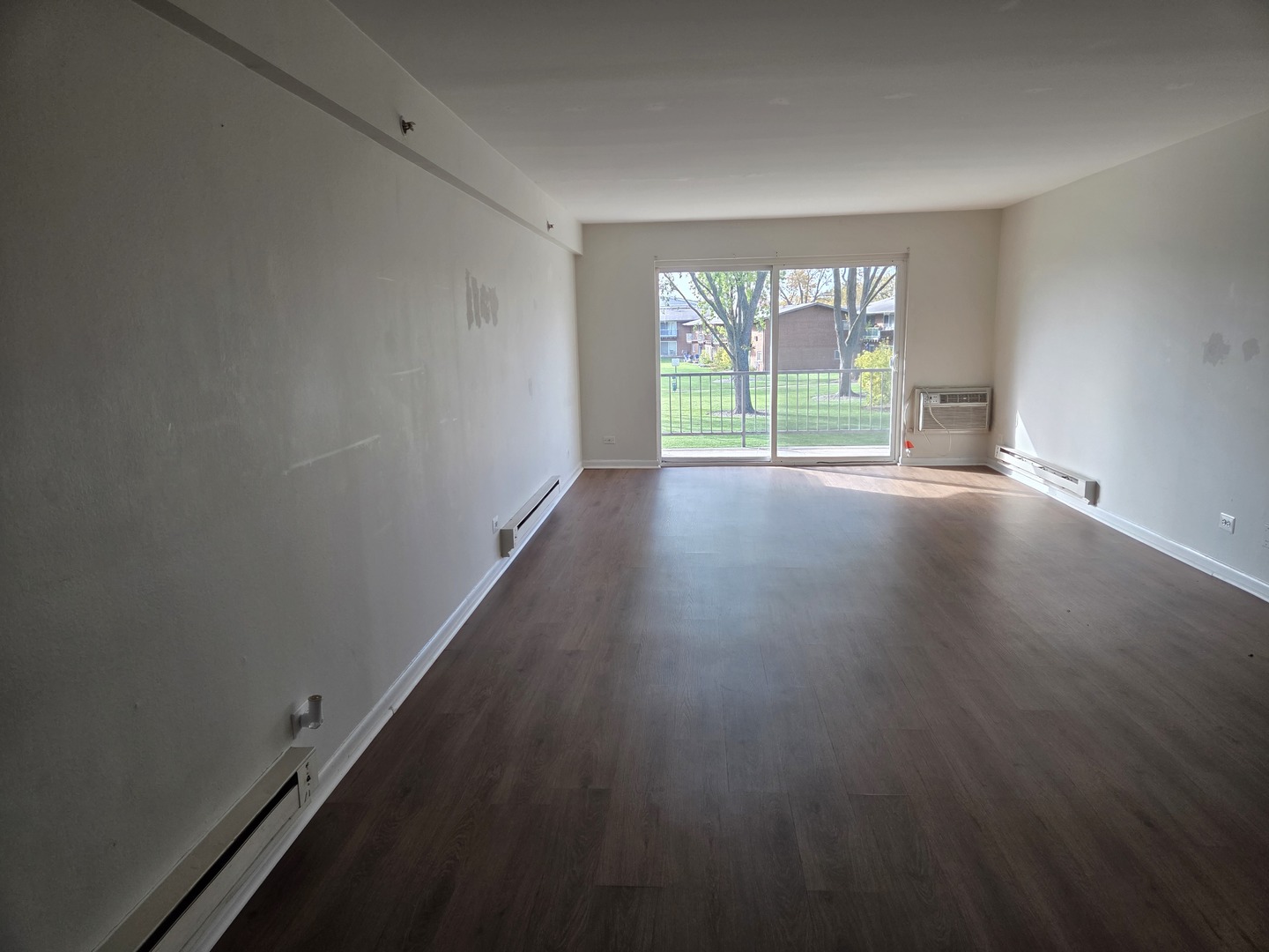 1500 Busse Road, Unit 2D Mount Prospect, IL 60056 - Photo 7 of 18 an empty room with wooden floor and windows