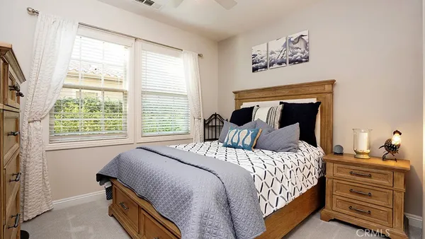a bedroom with a bed and large windows