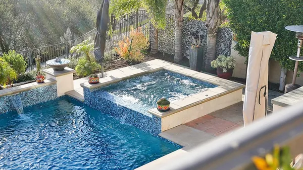 a view of a swimming pool with a patio and a yard