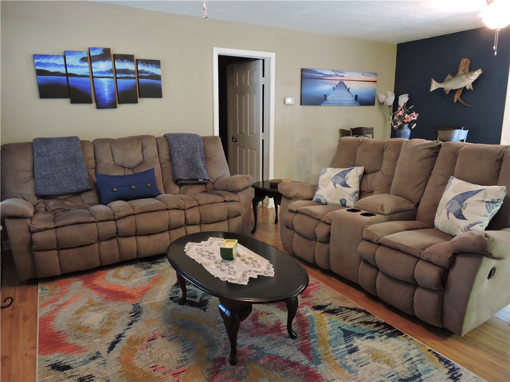1901 Hattons Ford Road Townville, SC 29689 - Photo 9 of 33 Hardwood flooring and a colorful area rug define this welcoming, spacious living area.
