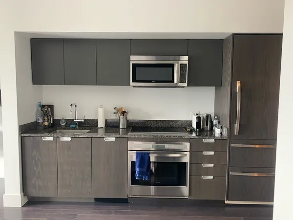 a kitchen with stainless steel appliances granite countertop a stove microwave and refrigerator