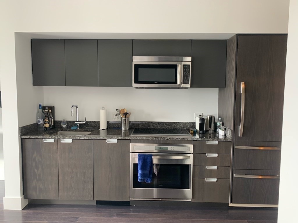 110 Stuart Street, Unit 24I Boston, MA 02116 - Photo 2 of 24 a kitchen with stainless steel appliances granite countertop a stove microwave and refrigerator
