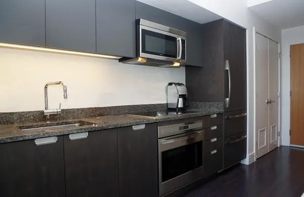 a kitchen with granite countertop a sink stainless steel appliances and cabinets