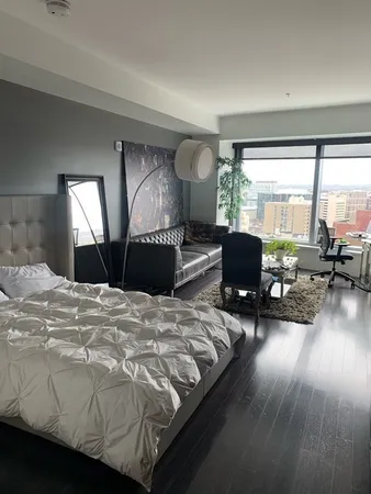 a bedroom with furniture and a large window
