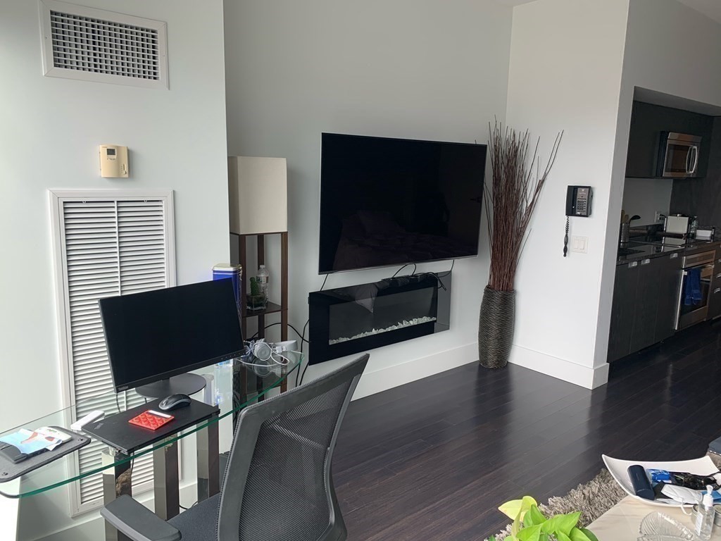 110 Stuart Street, Unit 24I Boston, MA 02116 - Photo 7 of 24 a living room with furniture and a flat screen tv
