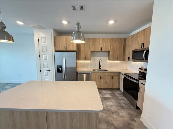 a large kitchen with kitchen island a sink stainless steel appliances and cabinets
