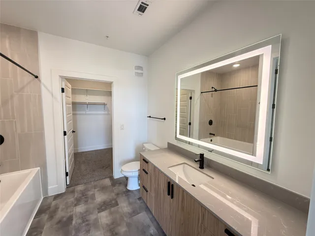 a bathroom with a double vanity sink toilet and shower