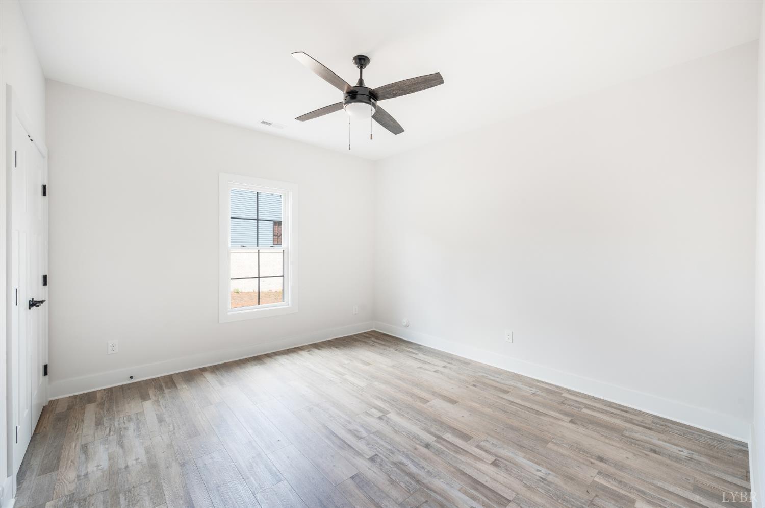 451 Dearborn Road Evington, VA 24550 - Photo 11 of 45 an empty room with wooden floor a ceiling fan and windows