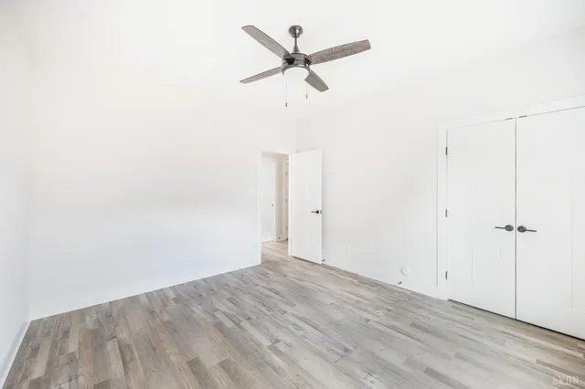 a large kitchen with granite countertop a stove top oven a sink a dishwasher and a dining table with wooden floor