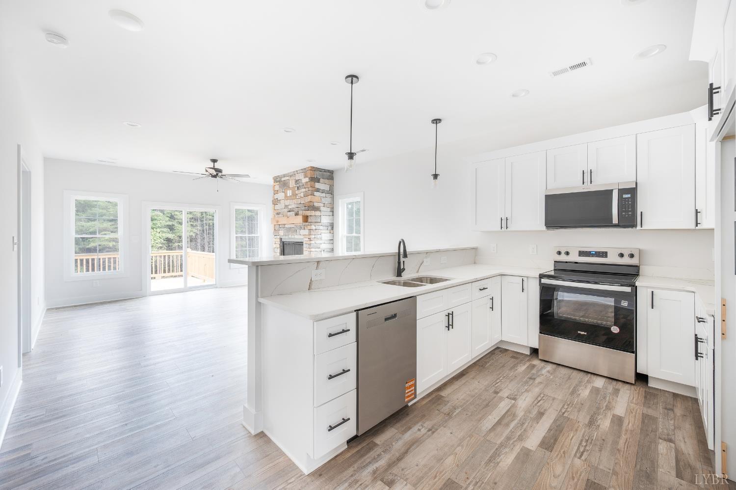 451 Dearborn Road Evington, VA 24550 - Photo 13 of 45 a large kitchen with granite countertop a stove top oven a sink a dishwasher and a dining table with wooden floor