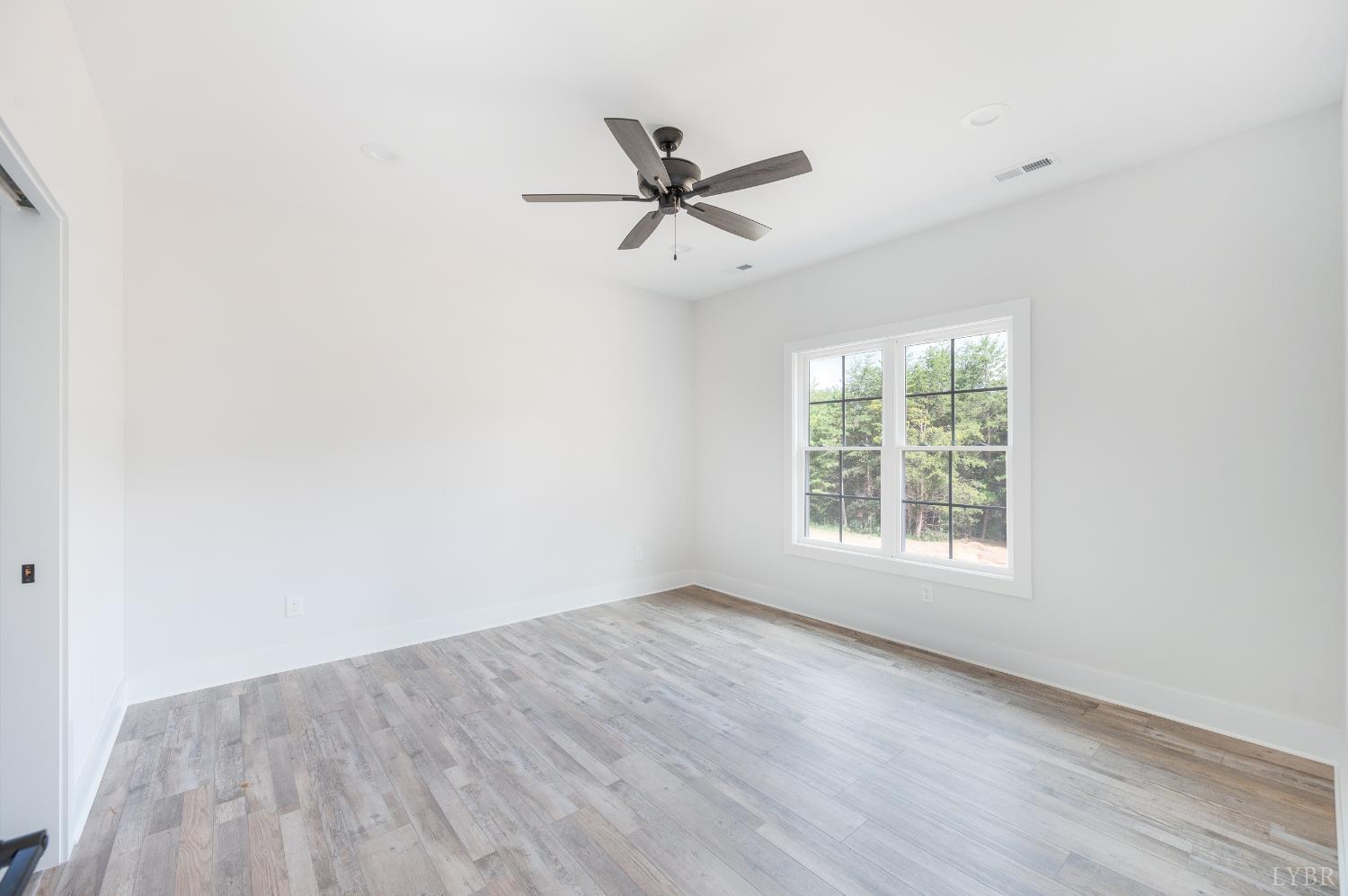 451 Dearborn Road Evington, VA 24550 - Photo 21 of 45 an empty room with wooden floor fan and windows