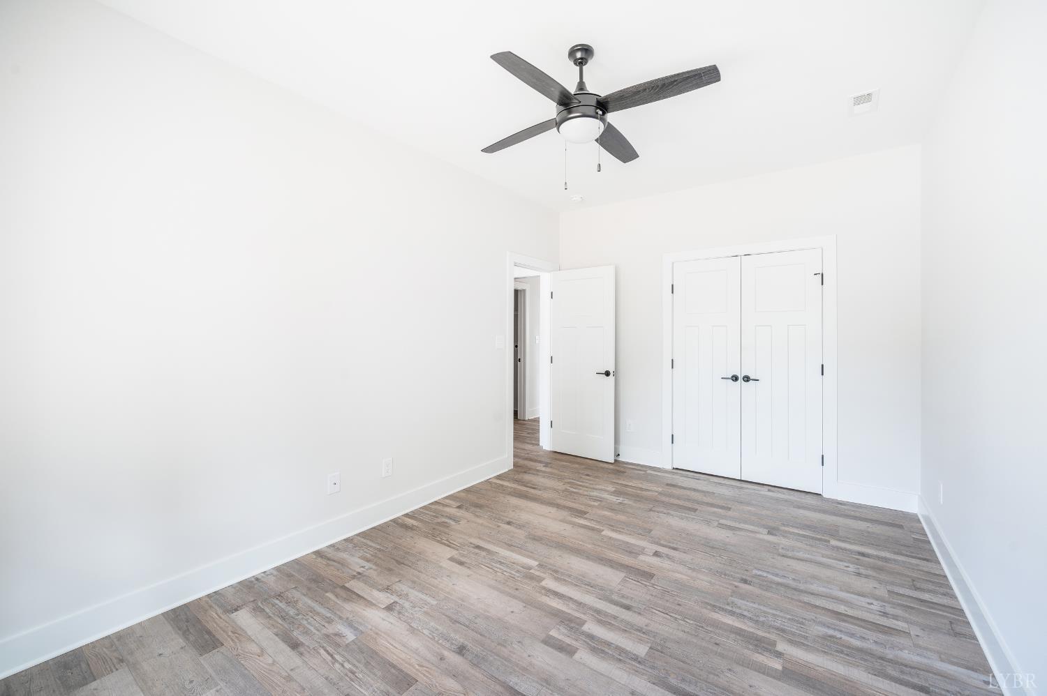 451 Dearborn Road Evington, VA 24550 - Photo 8 of 45 an empty room with wooden floor and ceiling fan