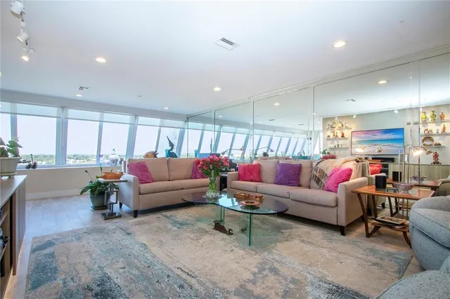 a living room filled with furniture and a view of kitchen