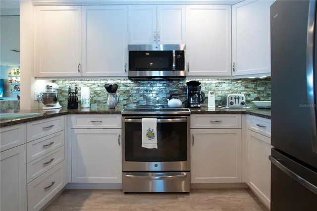 a living room with lots of furniture and kitchen view