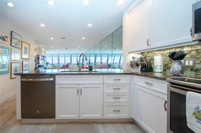 a living room filled with furniture a rug and a chandelier