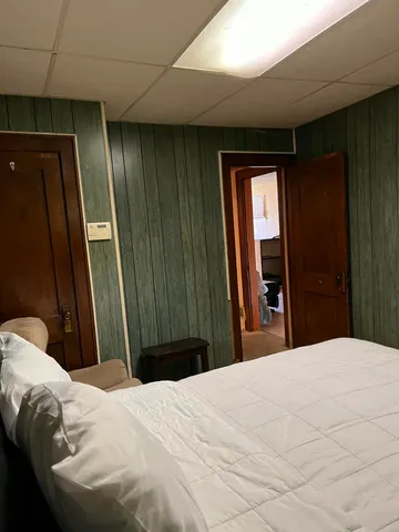 a bedroom with a bed and a large mirror
