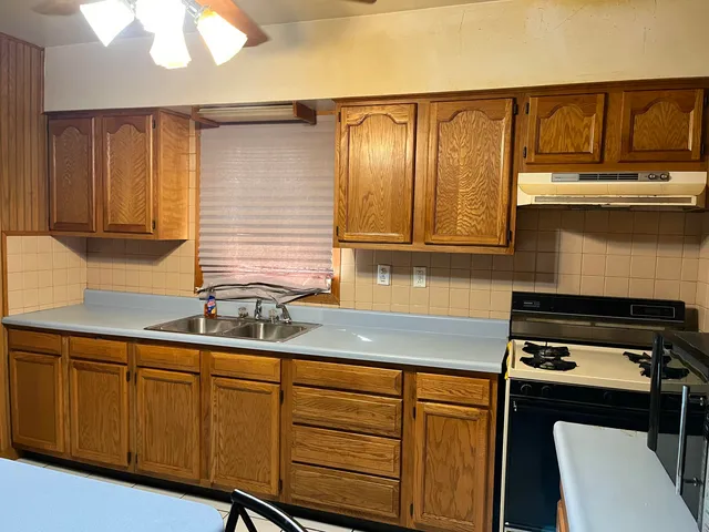 a kitchen with stainless steel appliances granite countertop a sink stove and cabinets