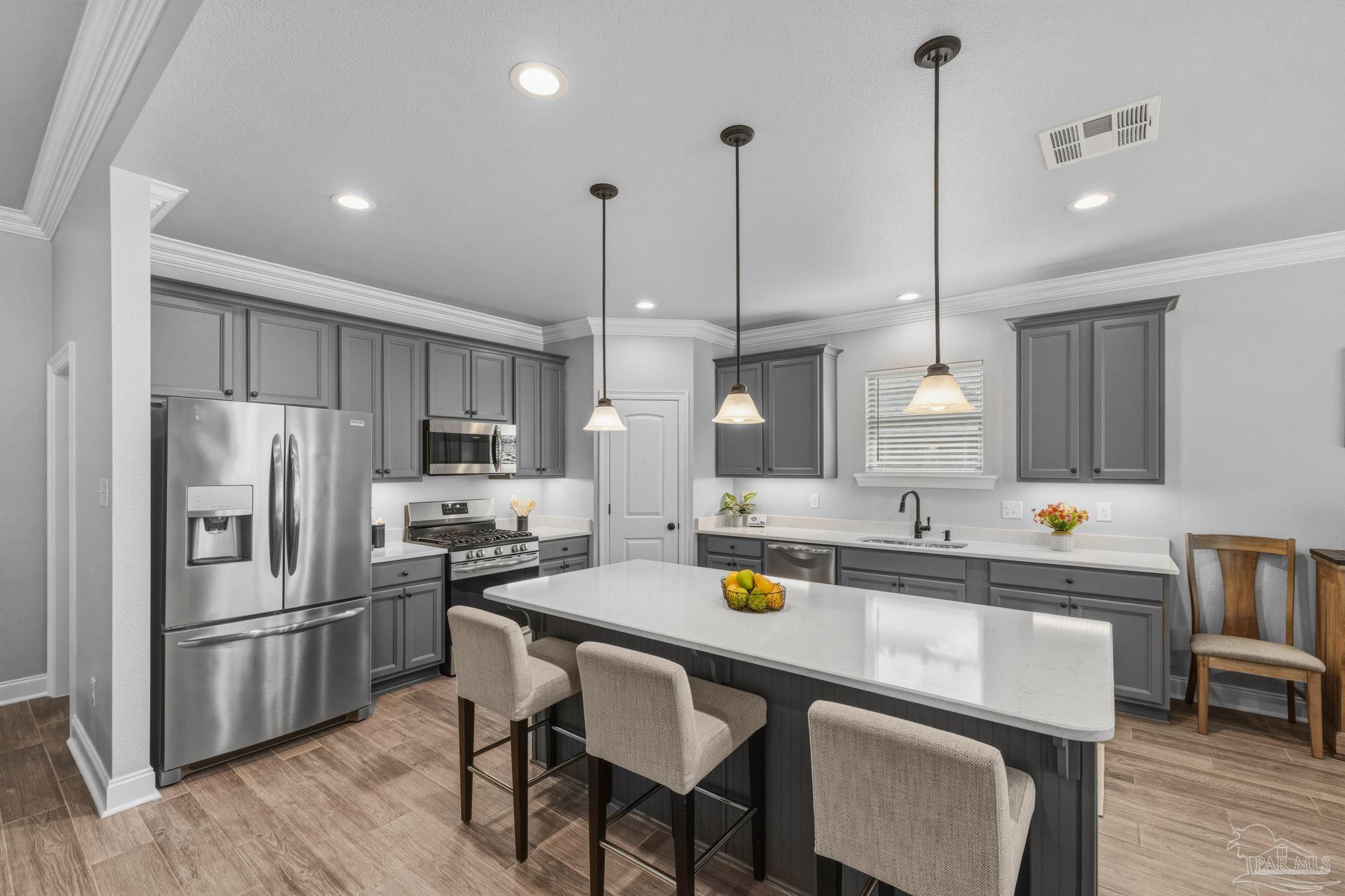 2129 Eagles Rdg Cove Cantonment, FL 32533 - Photo 17 of 66 a kitchen with a sink a refrigerator a counter and chairs