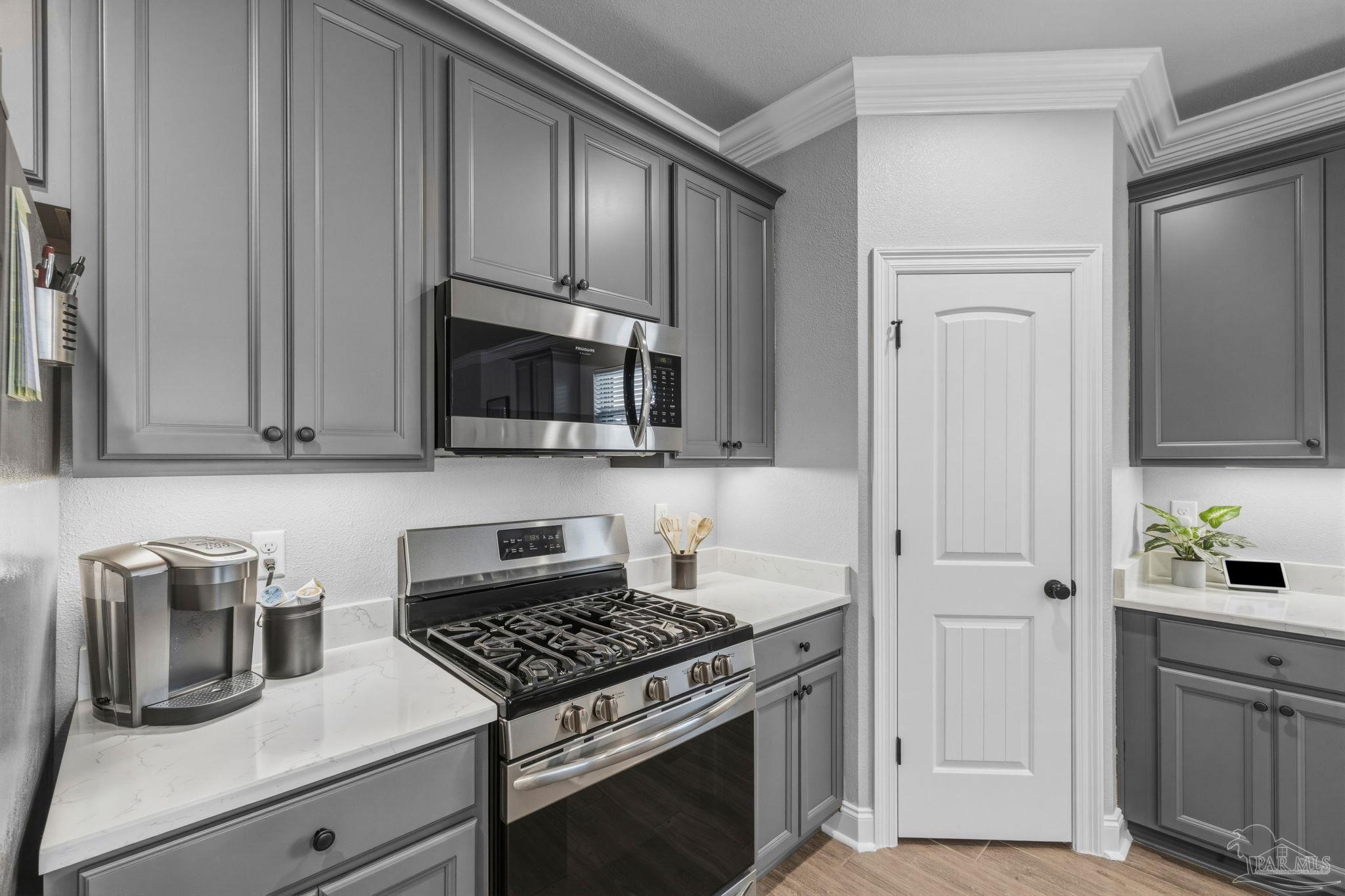 2129 Eagles Rdg Cove Cantonment, FL 32533 - Photo 19 of 66 a kitchen with white cabinets and black appliances
