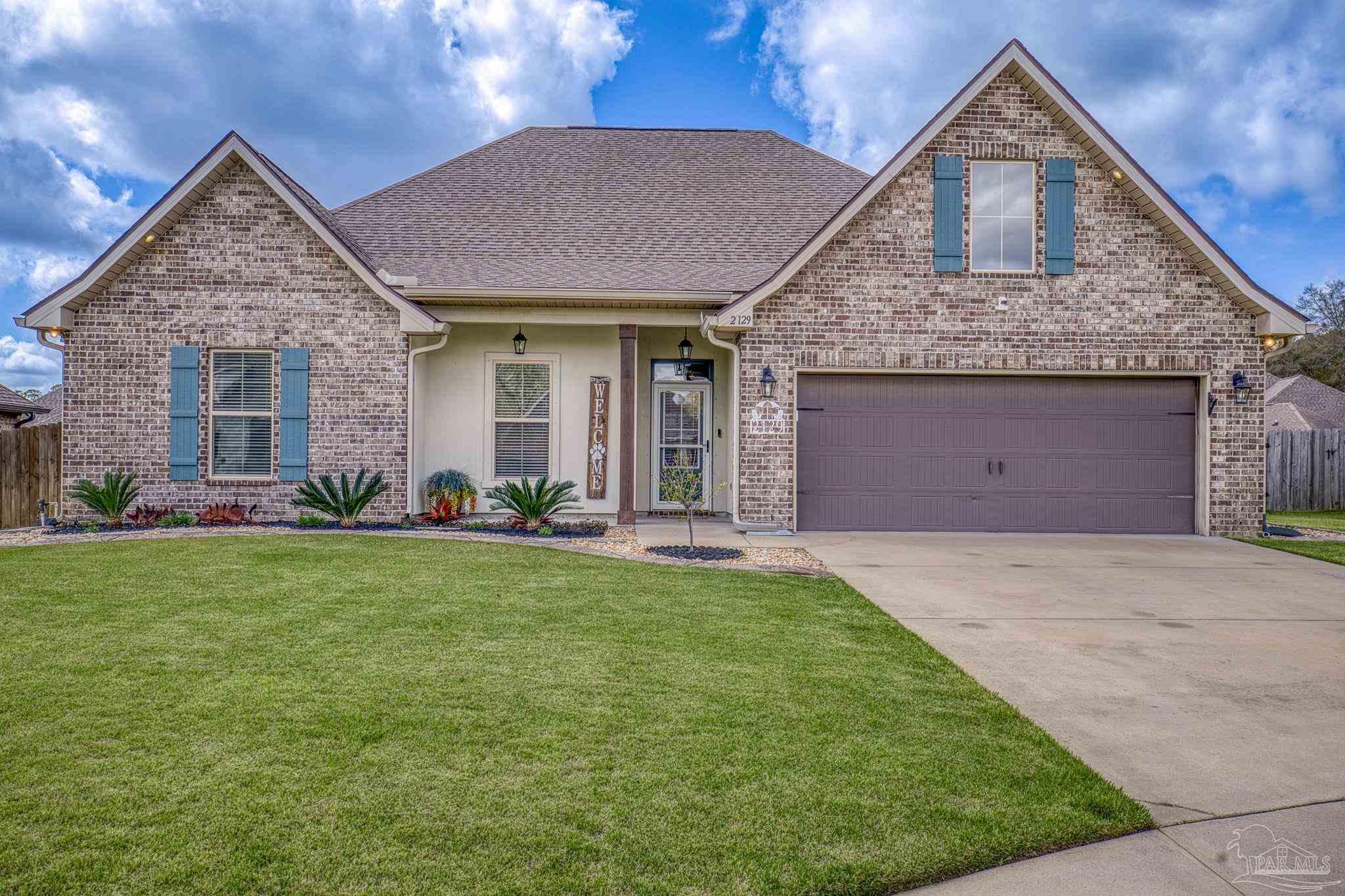 2129 Eagles Rdg Cove Cantonment, FL 32533 - Photo 3 of 66 a front view of a house with a yard and garage